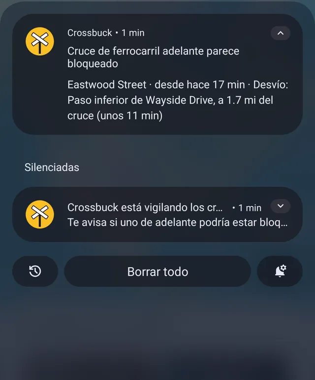 Una notificación de Crossbuck: el cruce de ferrocarril adelante parece bloqueado. Eastwood Street. Desvío: paso inferior de Wayside Drive, a 1.7 mi del cruce, unos 11 minutos.